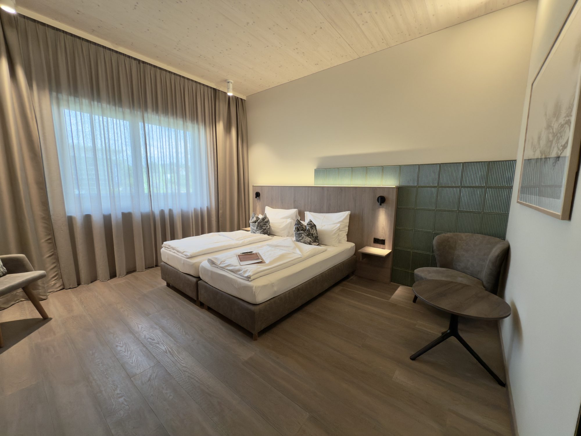 Barrierefreies Zimmer mit 28 m²: Doppelbett, Sessel und breite Bewegungsflächen ohne Stufen