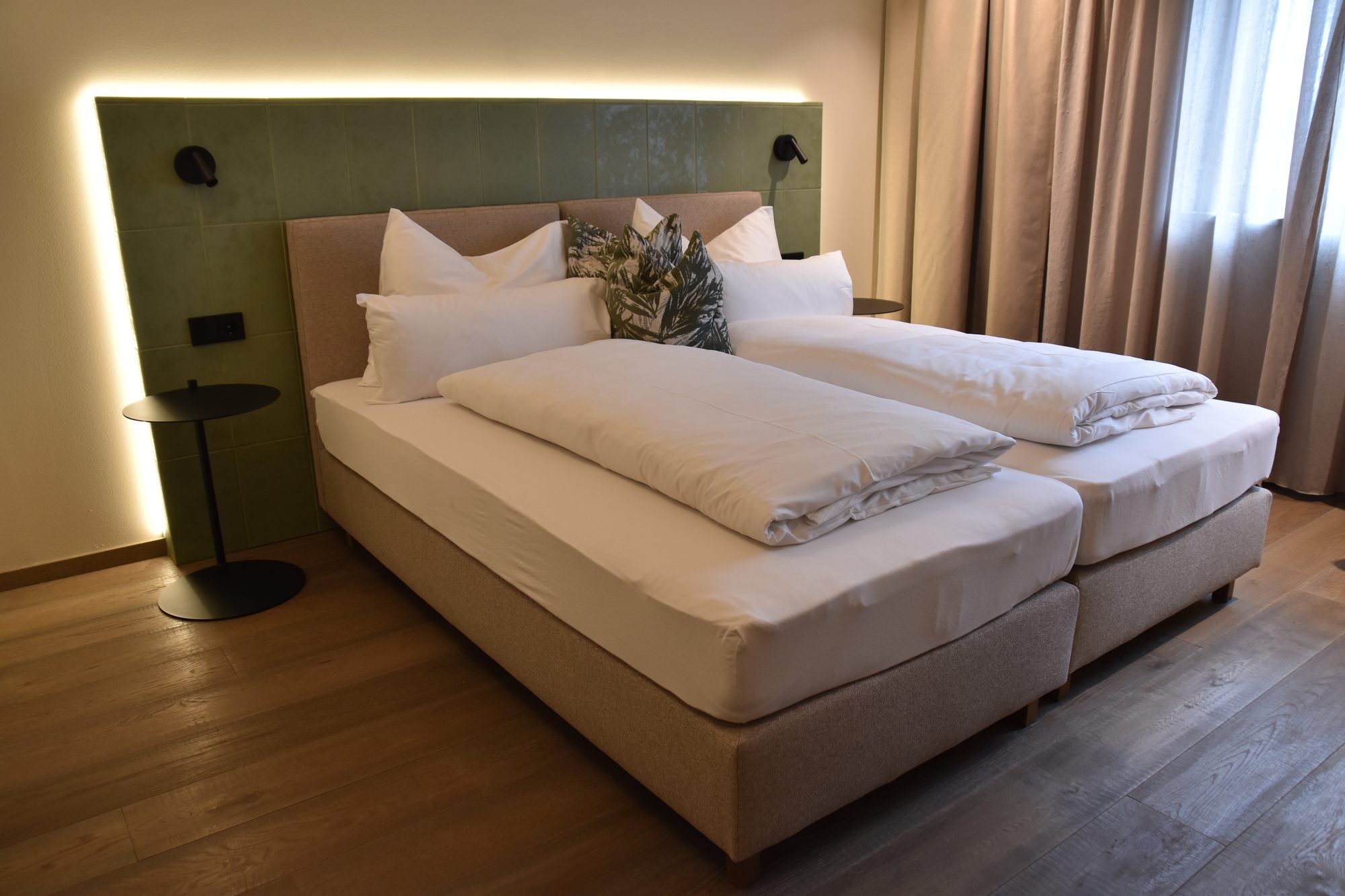 Zimmer Grünblick mit 27 m²: Doppelbett vor dem Kopfteil aus grün glasierten Kacheln
