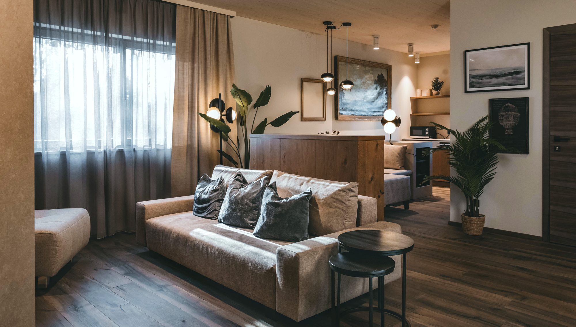 Suite Infinita im Hafnerhotel: Couch im Wohnbereich mit Blick zur offenen Küchenzeile
