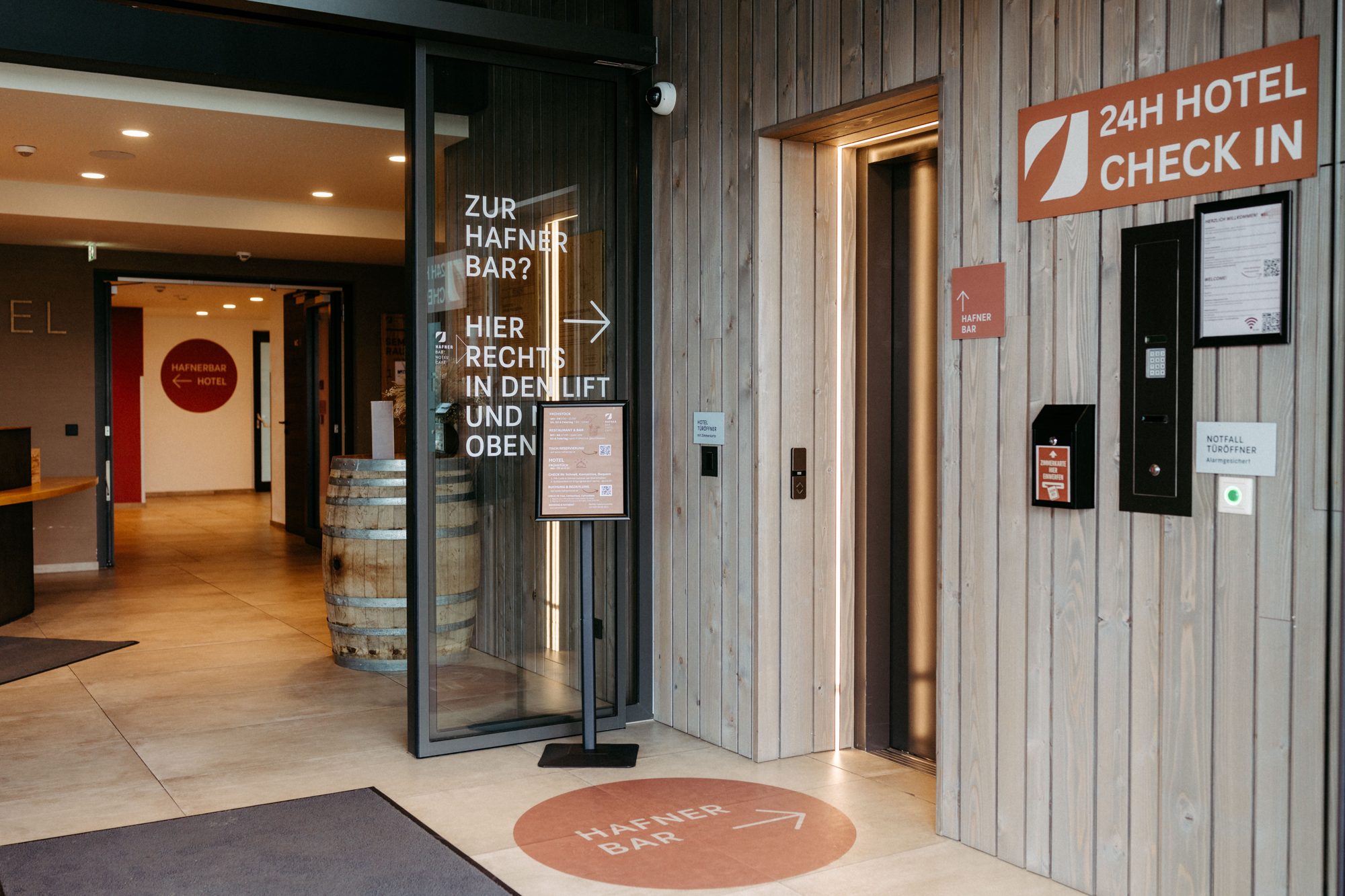 Eingangsbereich des Hafnerhotels mit Lift und Wegweiser zur HAFNERBAR